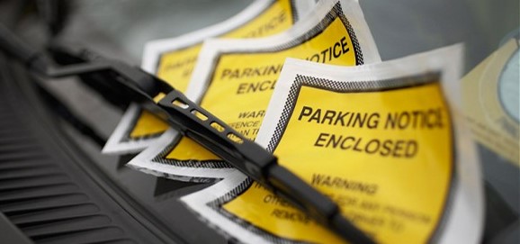 Image of a row of parking notices under a windshield wiper for a blog on top 5 New York driving laws people break