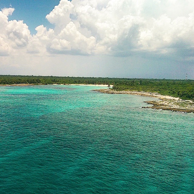 a body of water with land in the back with Lady Musgrave Island in the background